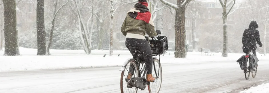 Personen fahren bei Schnee Fahrrad